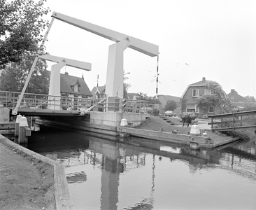 884302 Gezicht op de brug in de Stationsweg over de Ringvaart te Mijdrecht, met achter de brug de woningen Stationsweg 12-14.